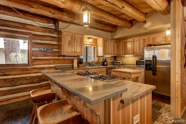 a kitchen with a sink a counter top space stainless steel appliances and cabinets