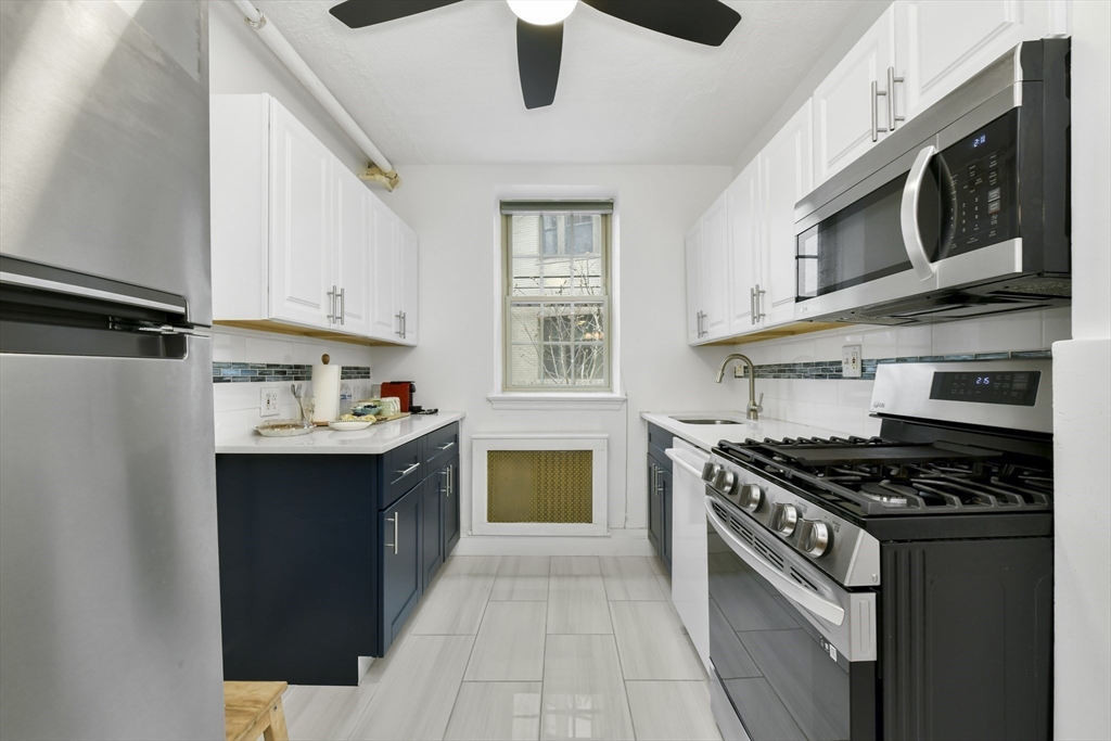 1490 Beacon Street, Unit 1A Brookline, MA 02446 - Photo 12 of 15 a kitchen with stainless steel appliances granite countertop a stove and a microwave