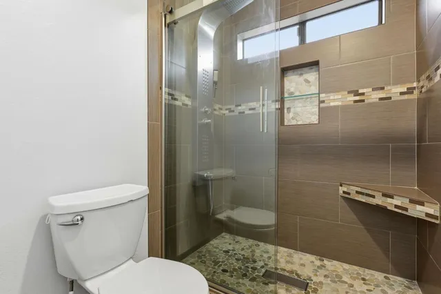 a bathroom with a toilet and a shower