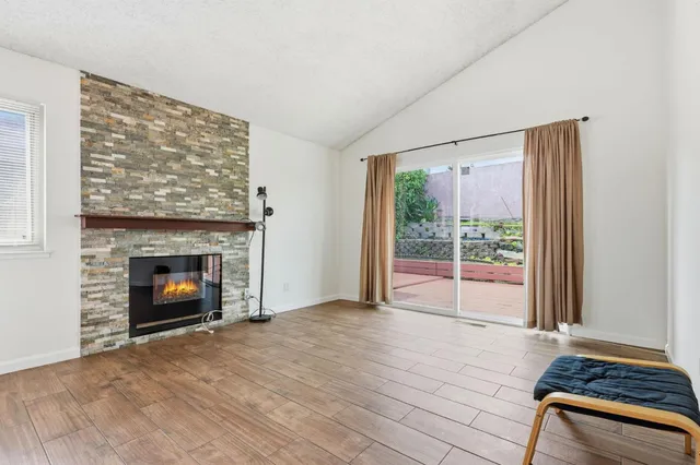 a view of an empty room with a fireplace and window