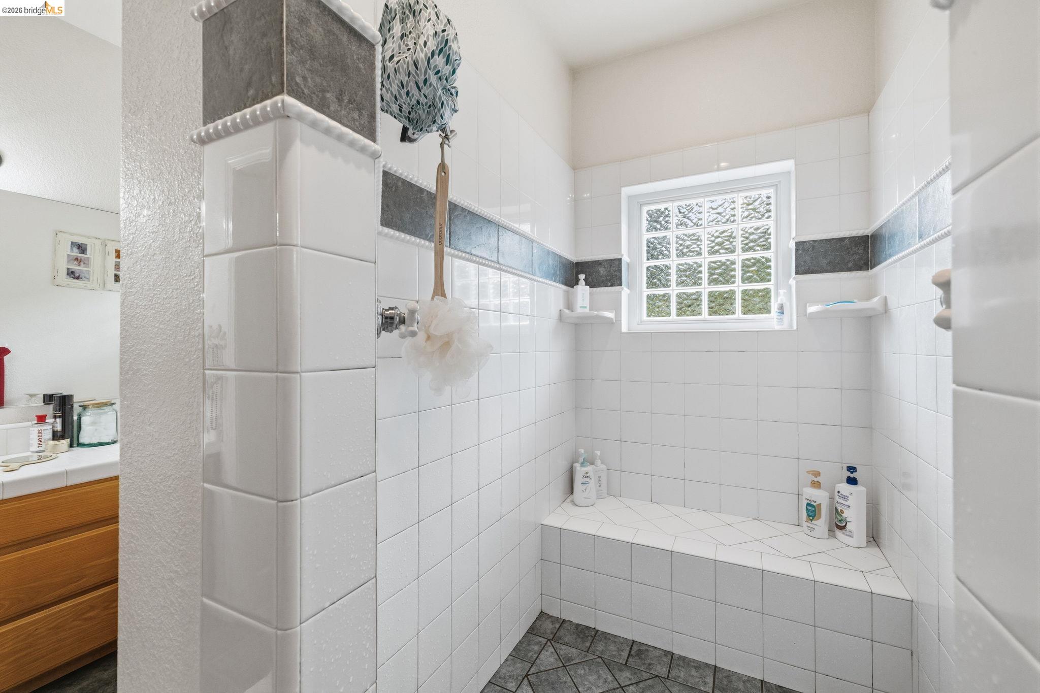 18450 Lambert Lake Road Sonora, CA 95370 - Photo 27 of 87 Shower with white subway tile walls, a built-in bench, and a glass block window