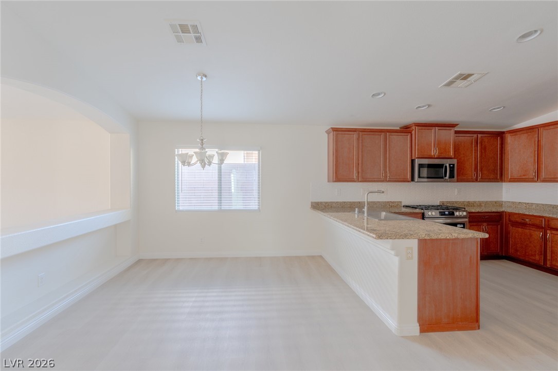 8079 Buffalo Ranch Avenue Las Vegas, NV 89147 - Photo 9 of 29 An open kitchen seamlessly connects with the adjacent dining space under recessed lighting.