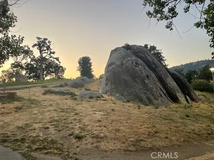 a view of a dry yard with wooden fence