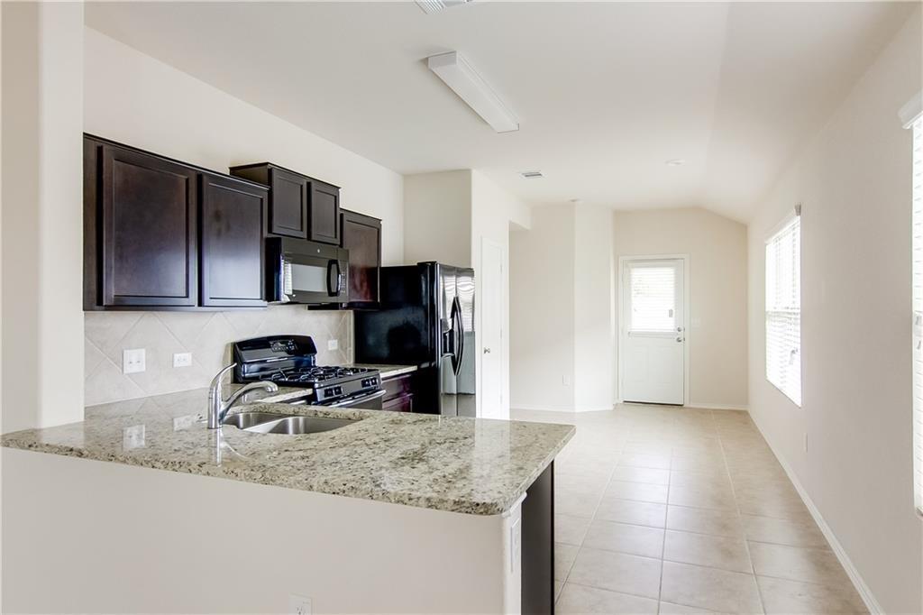 5916 Kennedy Street Austin, TX 78747 - Photo 3 of 25 a kitchen with stainless steel appliances granite countertop a sink stove and cabinets