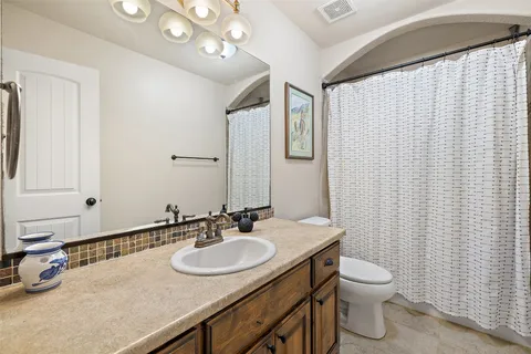 a bathroom with a sink vanity mirror and toilet