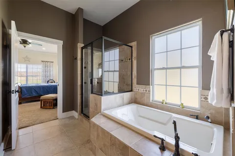a spacious bathroom with a tub and a large window