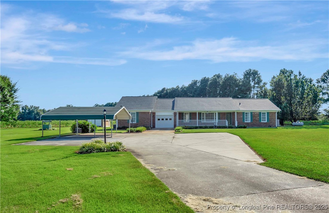 725 Henry Hammond Road Lumberton, NC 28360 - Photo 1 of 42 a front view of a house with a yard and trees