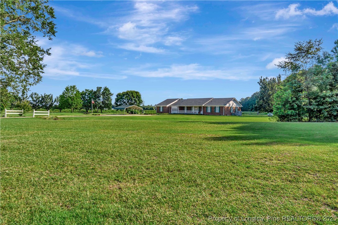 725 Henry Hammond Road Lumberton, NC 28360 - Photo 3 of 42 a view of a grassy field with trees