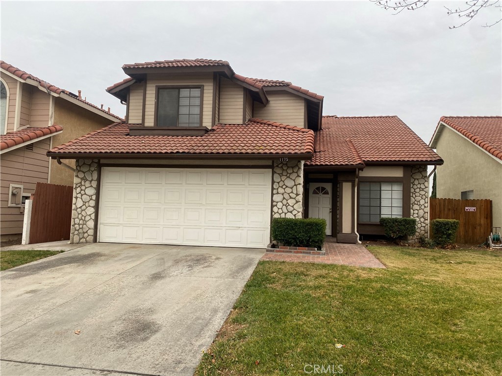 1175 West Victoria Street Rialto, CA 92376 - Photo 1 of 1 a front view of a house with a yard and garage