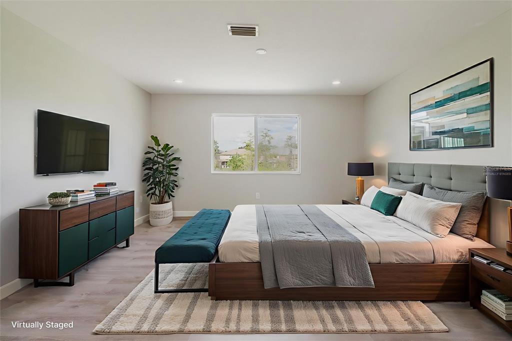 1725 Pink Guara Court Trinity, FL 34655 - Photo 15 of 100 a bedroom with a bed and a flat screen tv