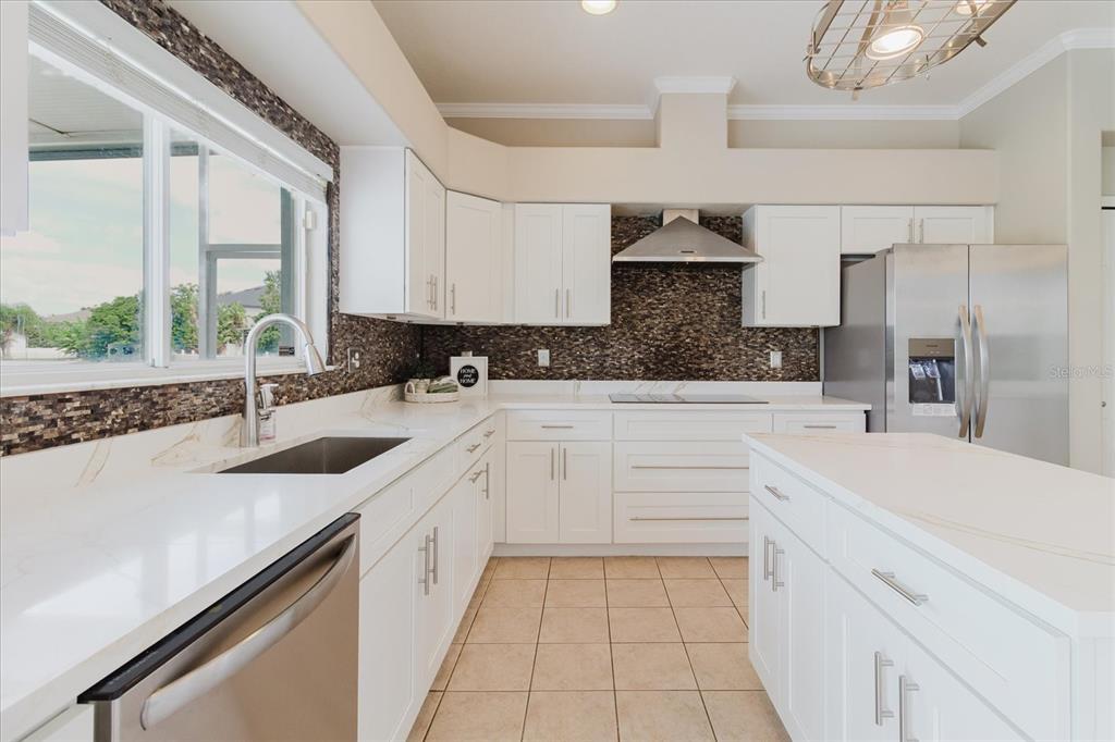 1725 Pink Guara Court Trinity, FL 34655 - Photo 35 of 100 a kitchen with a sink dishwasher a stove a washer and dryer with wooden floor