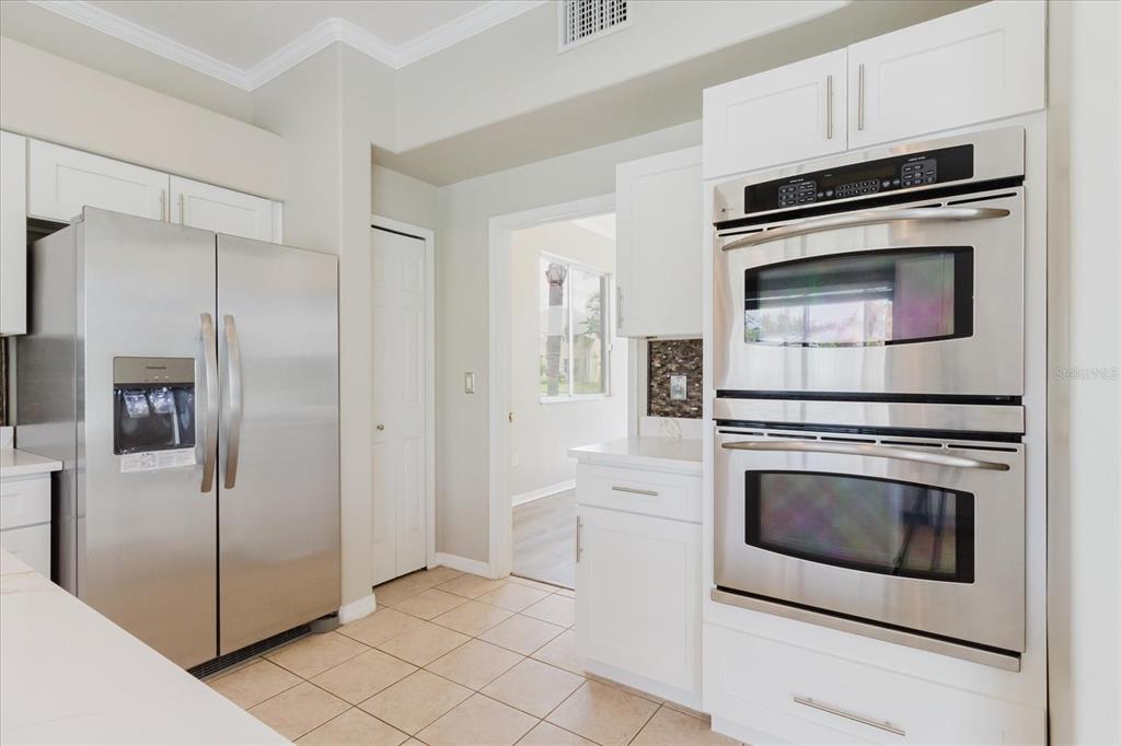 1725 Pink Guara Court Trinity, FL 34655 - Photo 40 of 100 a kitchen with white cabinets and stainless steel appliances