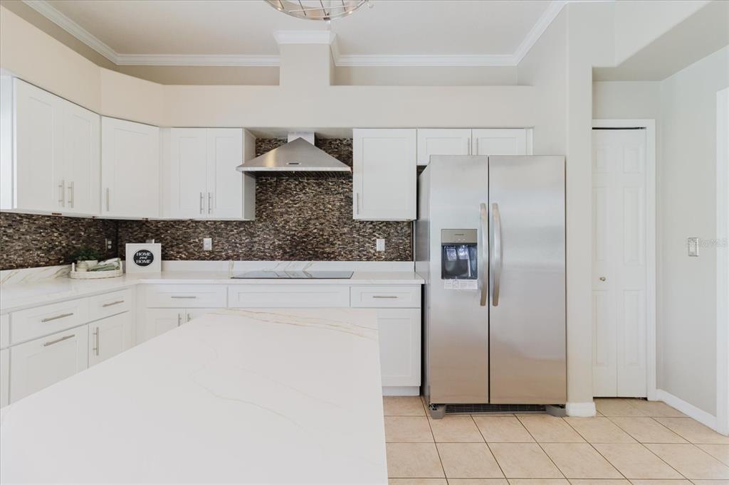 1725 Pink Guara Court Trinity, FL 34655 - Photo 42 of 100 a kitchen with stainless steel appliances granite countertop a refrigerator a sink and white cabinets