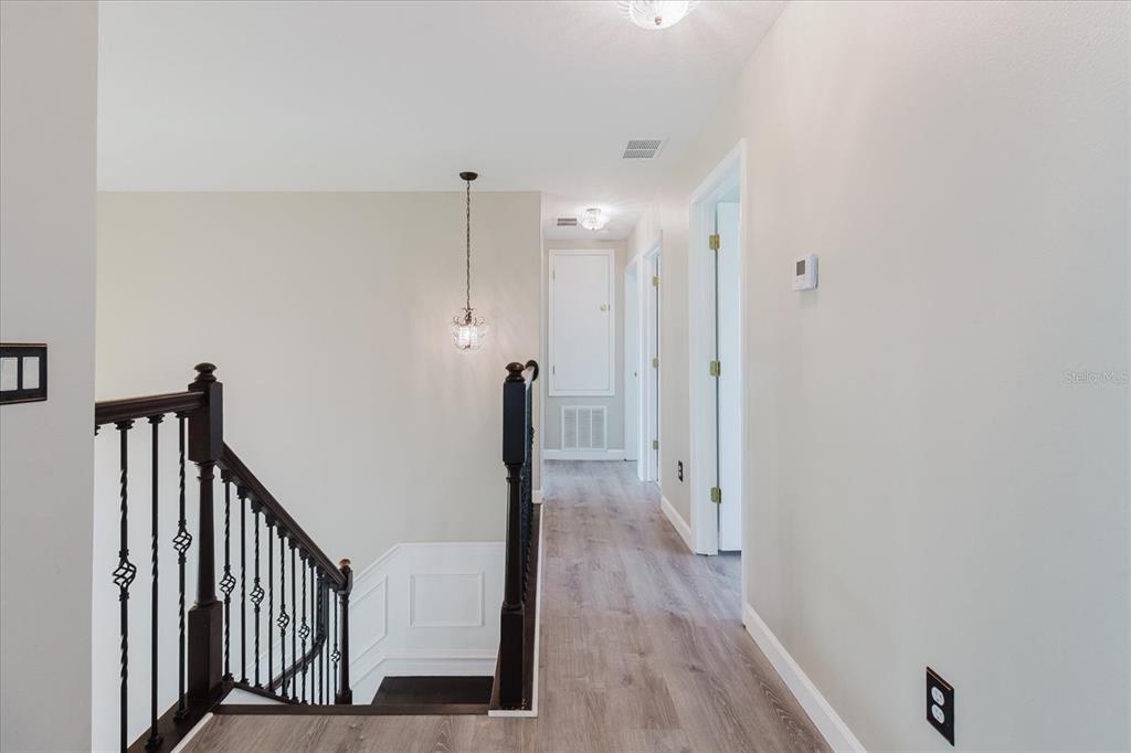 1725 Pink Guara Court Trinity, FL 34655 - Photo 49 of 100 a view of a hallway with wooden floor and staircase