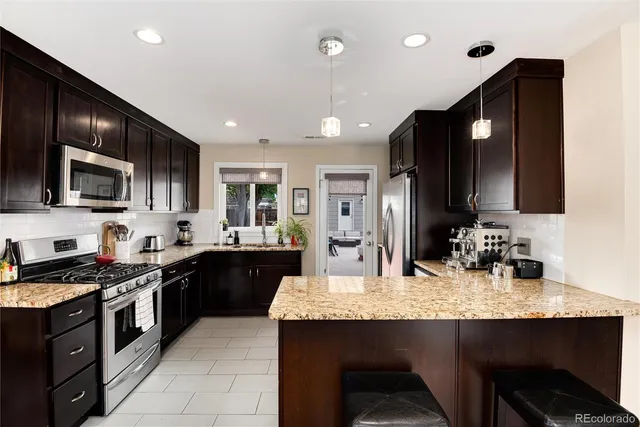 a kitchen with stainless steel appliances granite countertop wooden cabinets a stove top oven a sink and dishwasher