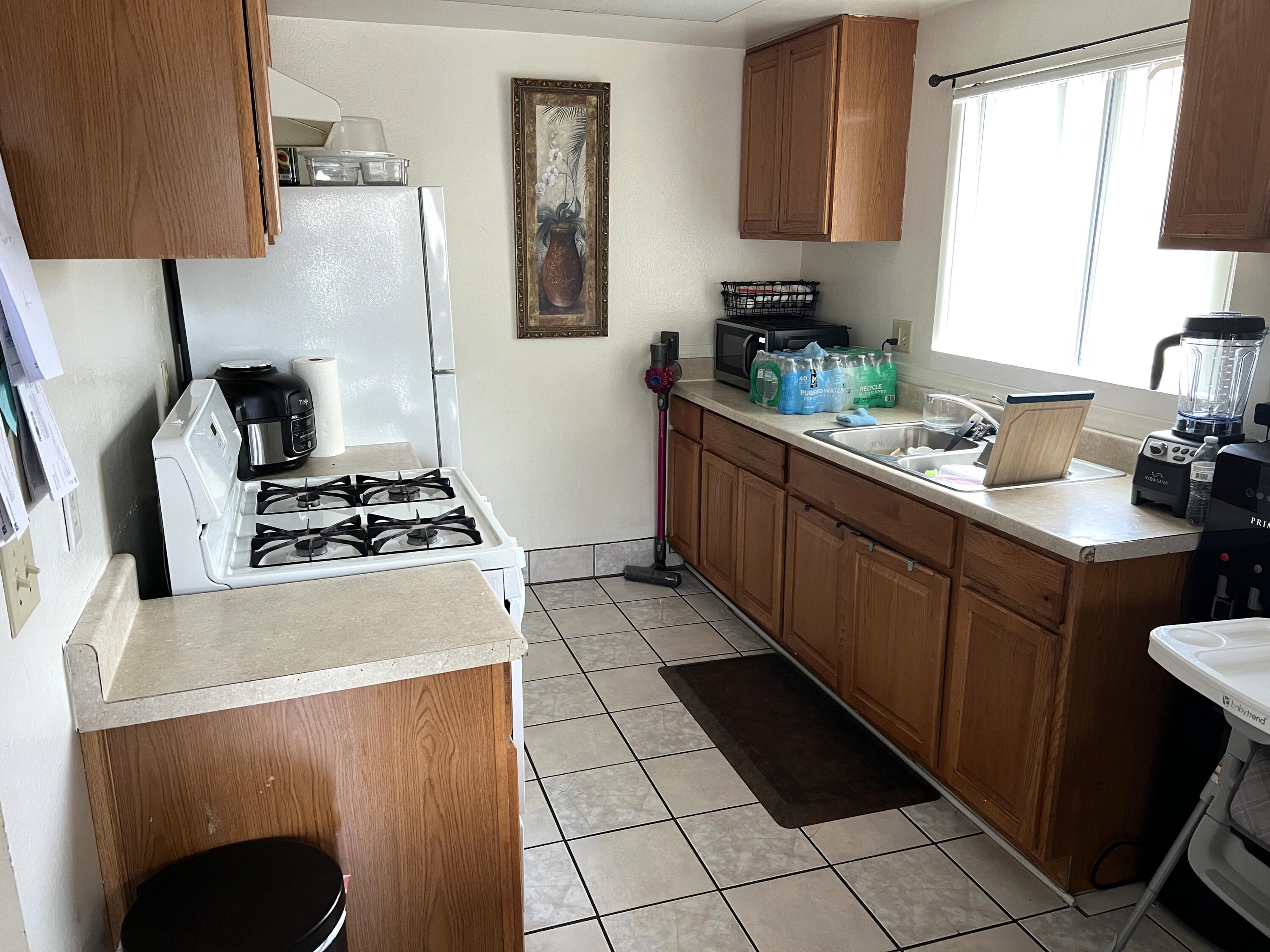 1241 West 7th Street, Unit 1 Oxnard, CA 93030 - Photo 7 of 8 a kitchen with a sink a stove and a refrigerator