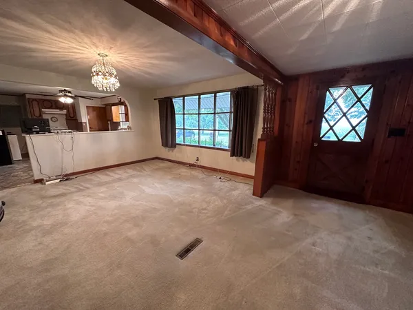 en empty room with windows and ceiling fan