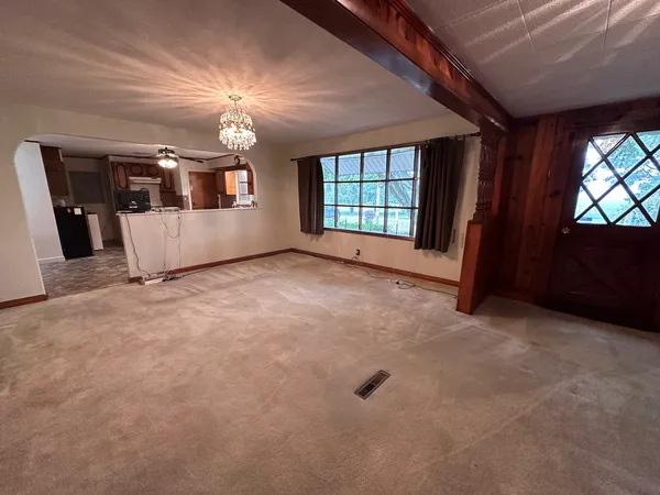 en empty room with windows and ceiling fan