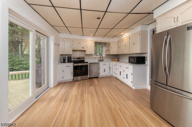 7 Capstan Road West Milford, NJ 07480 - Photo 8 of 33 a kitchen with stainless steel appliances granite countertop a refrigerator a sink dishwasher a stove and white countertops with wooden floor