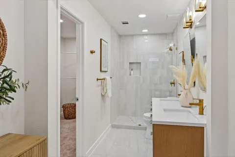 a bathroom with a sink a toilet and shower