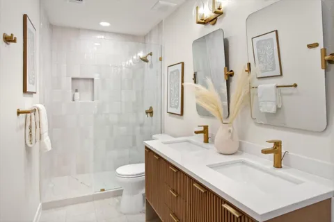 a bathroom with a sink a toilet and shower