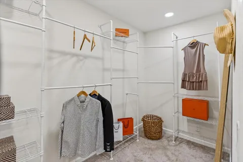 a view of walk in closet with clothes and shoes