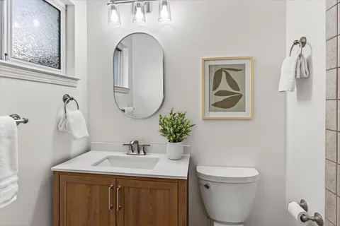 a bathroom with a toilet sink and mirror