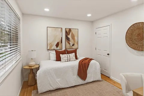 a bedroom with a bed and a painting on the wall