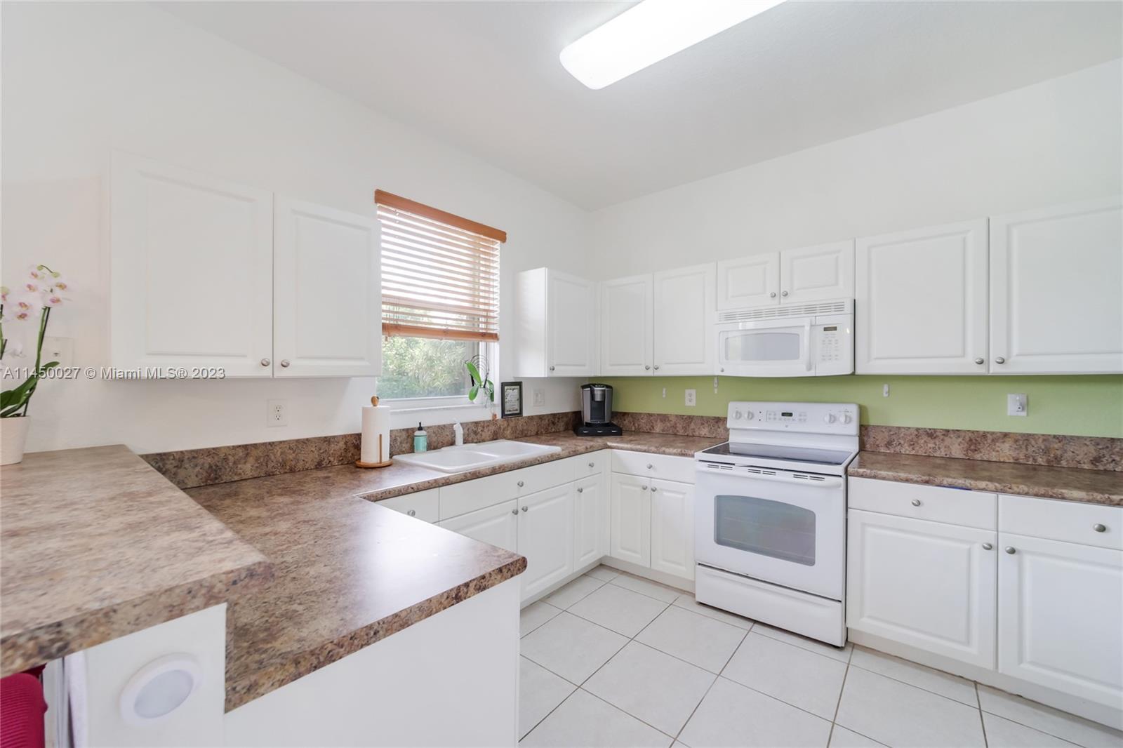 12953 Southwest 132nd Terrace Miami, FL 33186 - Photo 11 of 36 a kitchen with cabinets appliances and a sink
