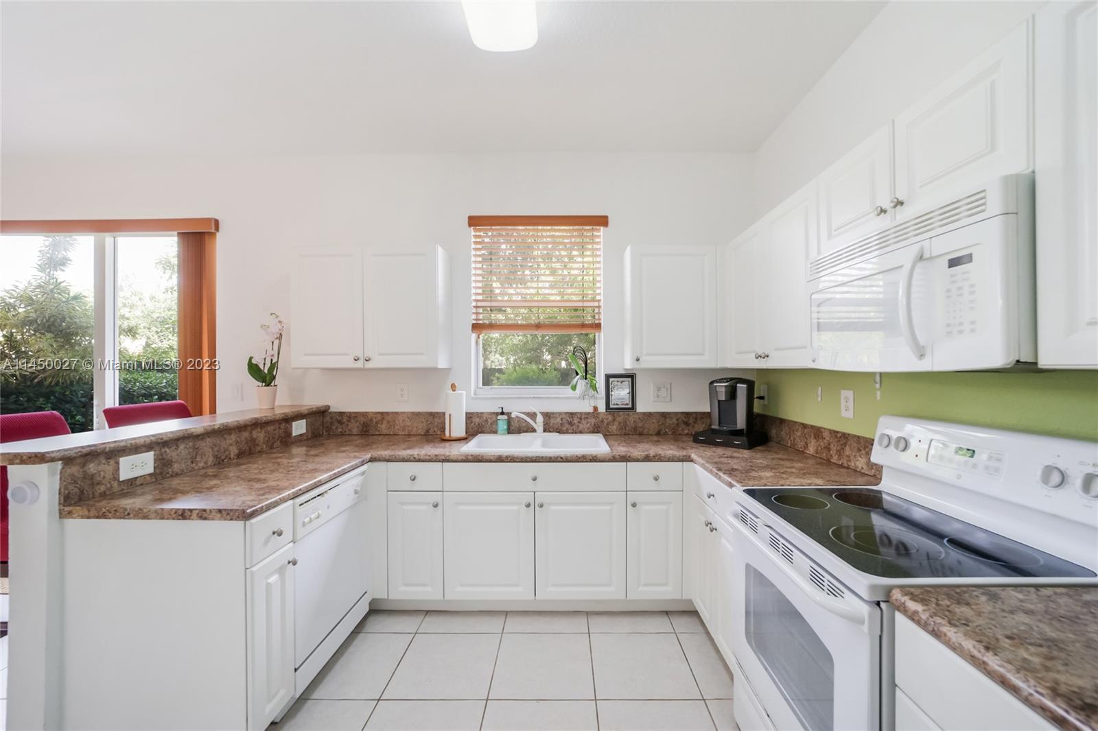 12953 Southwest 132nd Terrace Miami, FL 33186 - Photo 12 of 36 a kitchen with a sink stove and cabinets