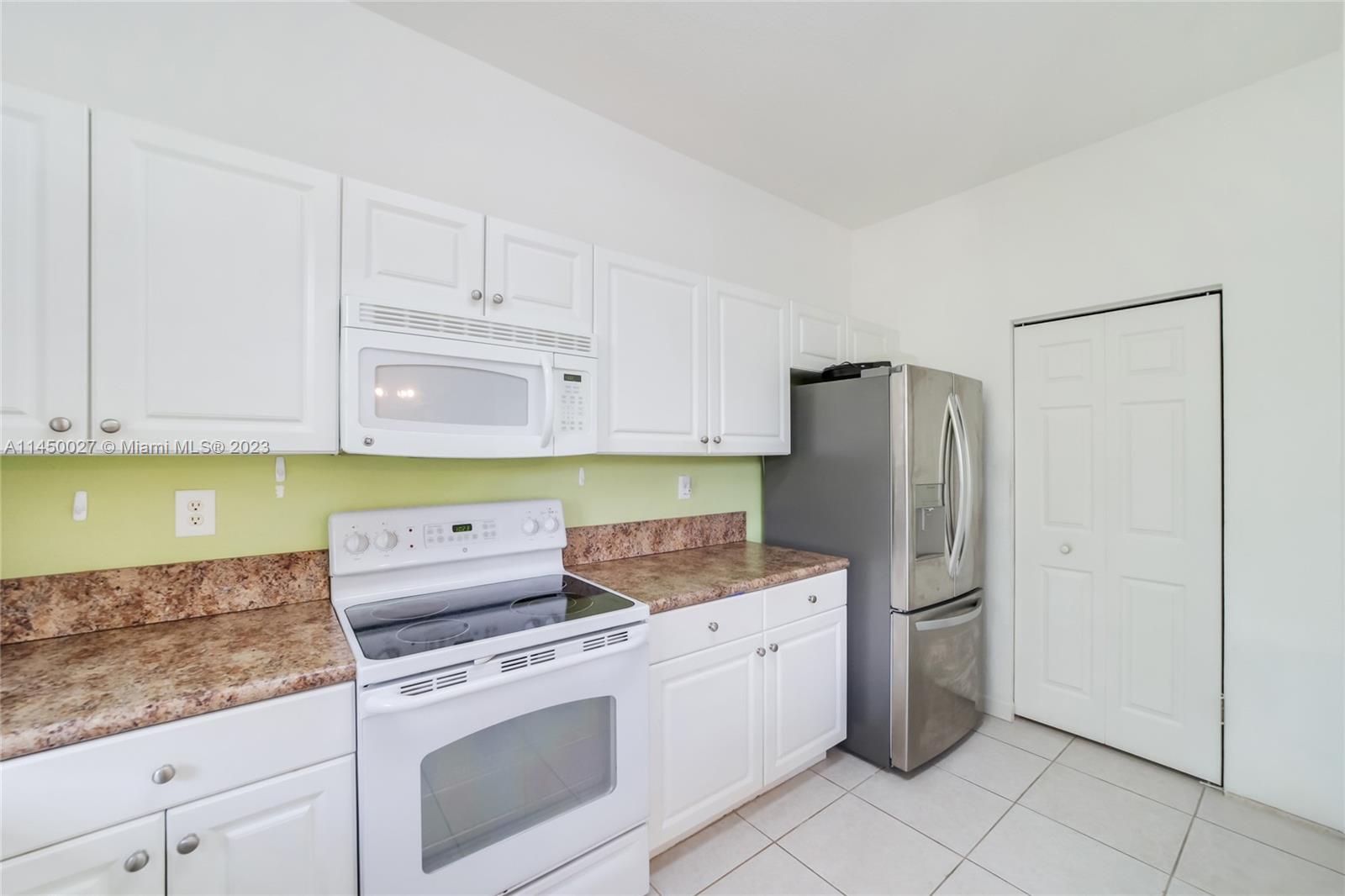 12953 Southwest 132nd Terrace Miami, FL 33186 - Photo 13 of 36 a kitchen with a refrigerator sink and cabinets