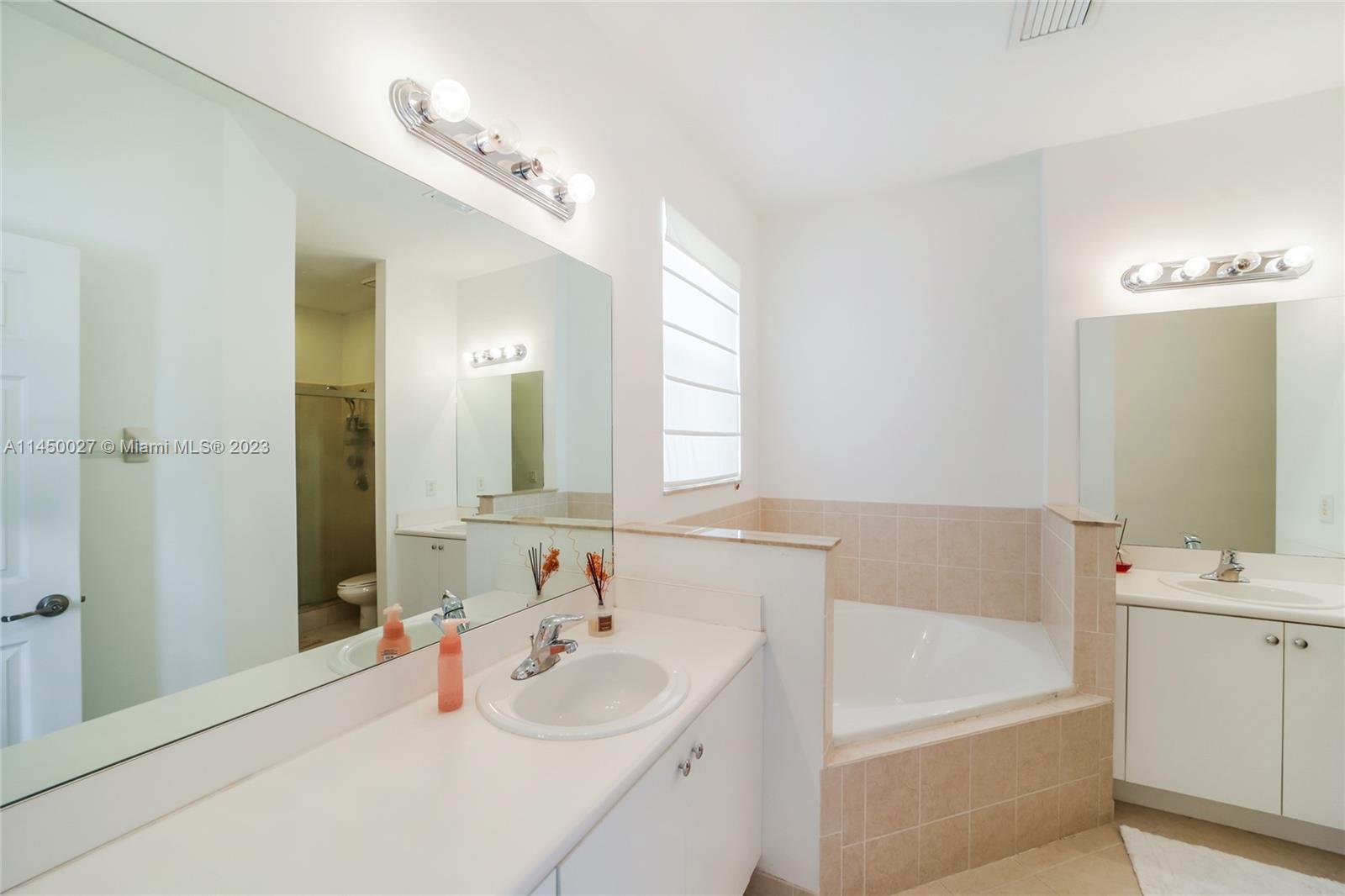 12953 Southwest 132nd Terrace Miami, FL 33186 - Photo 23 of 36 a bathroom with a tub sink and mirror