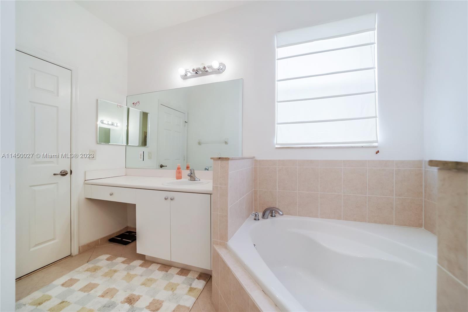 12953 Southwest 132nd Terrace Miami, FL 33186 - Photo 25 of 36 a bathroom with a bathtub sink and mirror