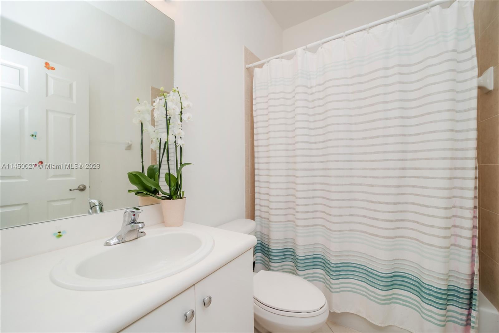 12953 Southwest 132nd Terrace Miami, FL 33186 - Photo 28 of 36 a bathroom with a sink a toilet and shower curtain