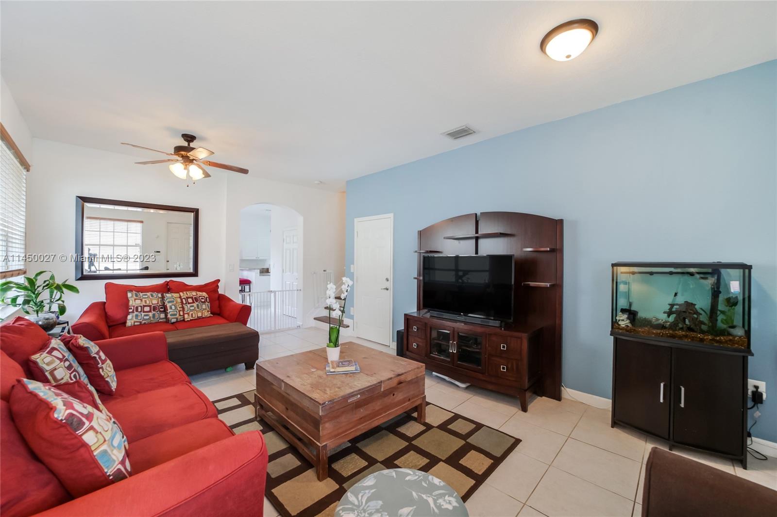12953 Southwest 132nd Terrace Miami, FL 33186 - Photo 5 of 36 a living room with furniture and a flat screen tv