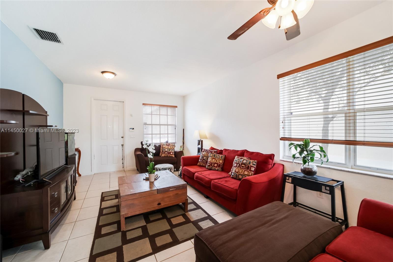 12953 Southwest 132nd Terrace Miami, FL 33186 - Photo 6 of 36 a living room with furniture a flat screen tv and a window