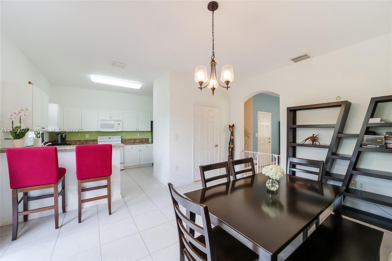 12953 Southwest 132nd Terrace Miami, FL 33186 - Photo 10 of 36 a view of a dining room and livingroom with furniture wooden floor a rug a painting and a chandelier