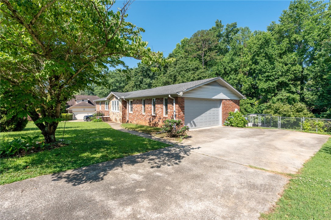 200 Echo Circle Easley, SC 29642 - Photo 34 of 35 A well-maintained ranch home with a spacious driveway, surrounded by mature trees.