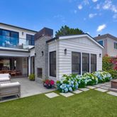 a front view of a house with a garden and patio