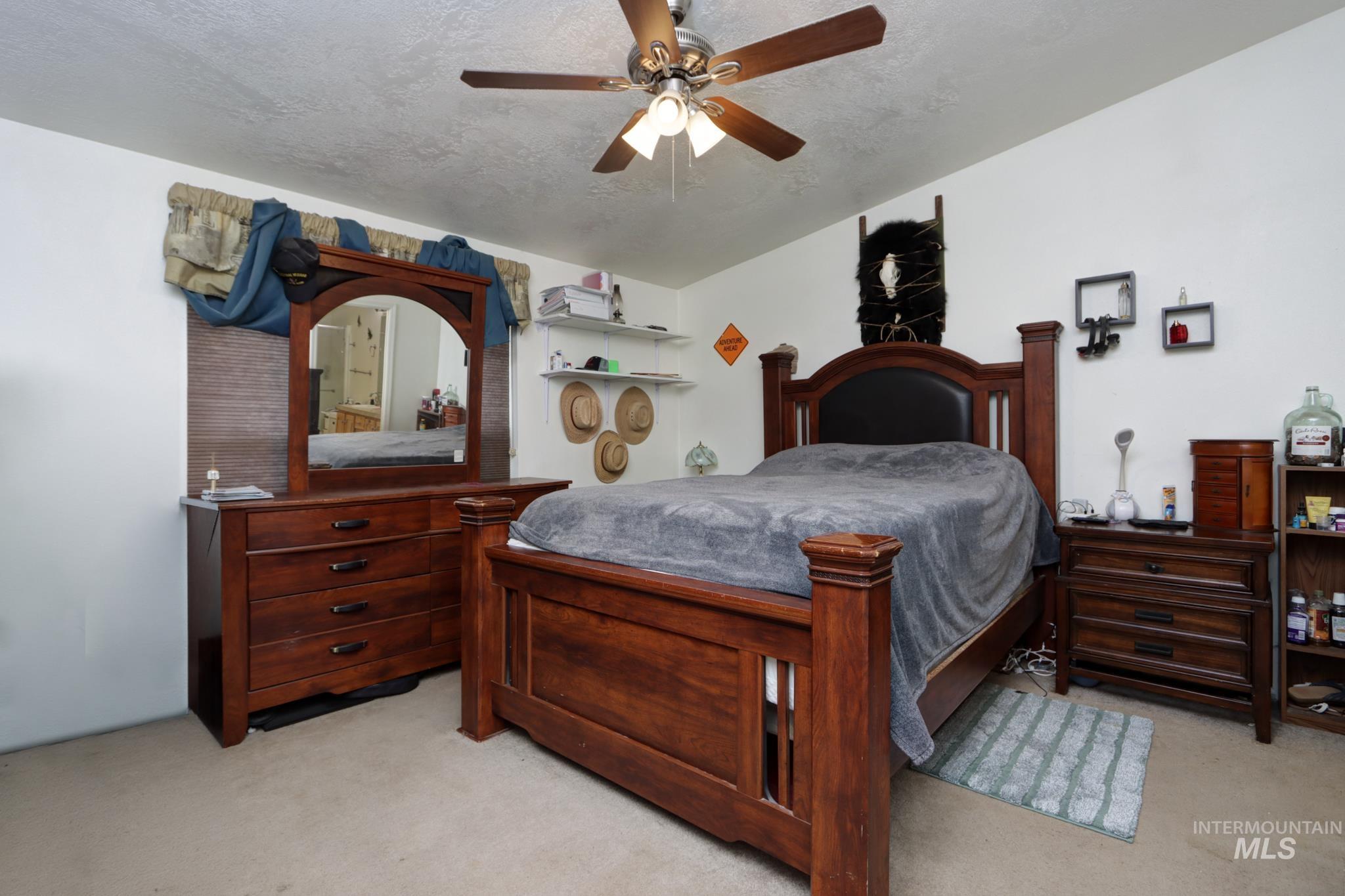 1583 Dustin Lane Vale, OR 97918 - Photo 15 of 39 Bedroom featuring light colored carpet, a ceiling fan, and a textured ceiling