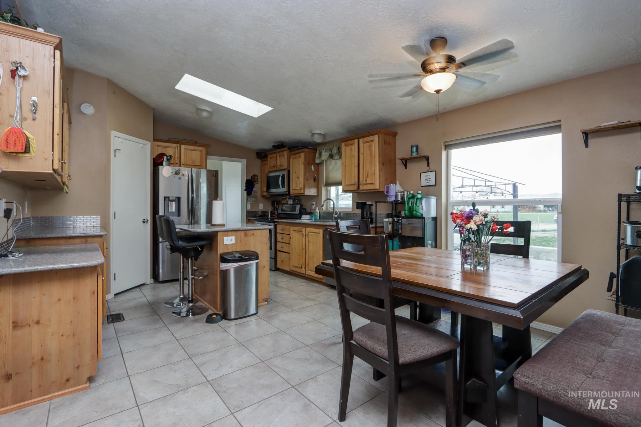1583 Dustin Lane Vale, OR 97918 - Photo 9 of 39 Dining area with a skylight, lofted ceiling, ceiling fan, and light tile patterned floors