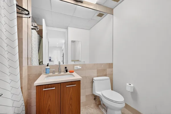 a bathroom with a sink vanity mirror and toilet