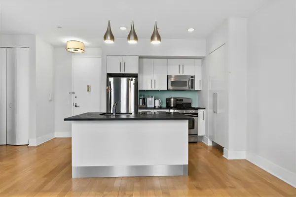 a kitchen with stainless steel appliances granite countertop a stove a sink and a refrigerator