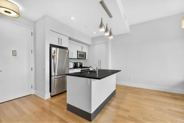 a kitchen with stainless steel appliances a refrigerator a sink a stove a microwave and island