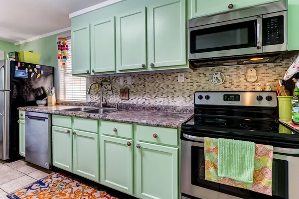 a kitchen with stainless steel appliances granite countertop a stove and a microwave