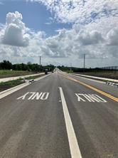 Tbd Barnhardt Road Temple, TX 76502 - Photo 2 of 7 Smooth, newly paved road stretches into the distance, framed by open sky and emerging curbs.
