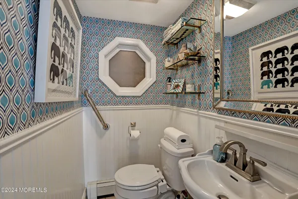 a bathroom with a toilet a sink and a mirror