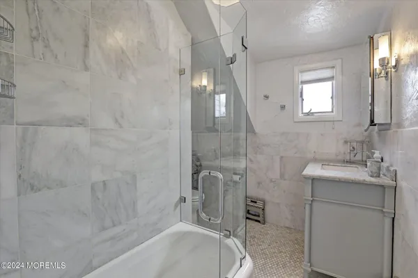 a bathroom with a granite countertop sink a toilet and shower