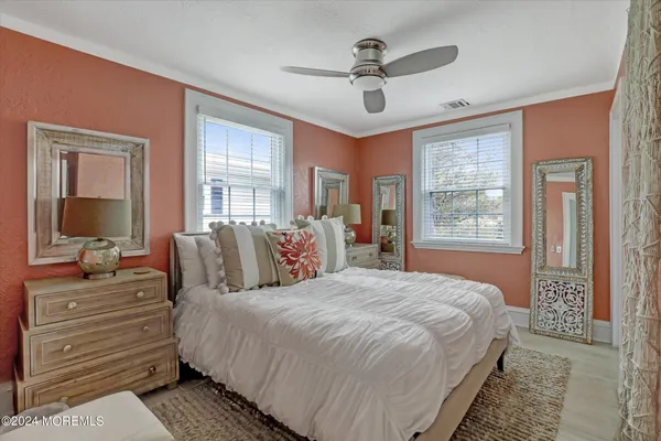 a bedroom with a large bed and windows