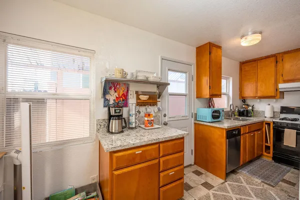 a kitchen with stainless steel appliances granite countertop a stove a sink and a refrigerator